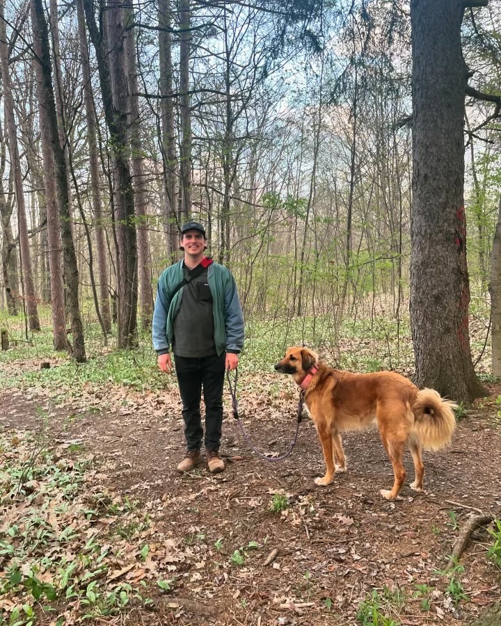 Nicholas on a hiking trail with his dog, a tan Saluki mix.